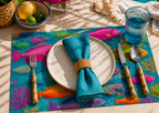 Bright coastal fish disposable paper placemat from The Daily Catch pad on a summer table